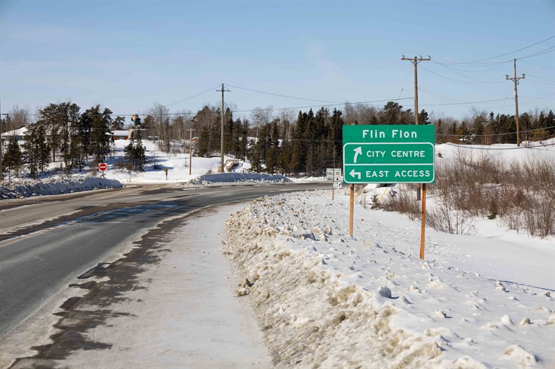 A highway sign indicating directions for passing through Flin Flon